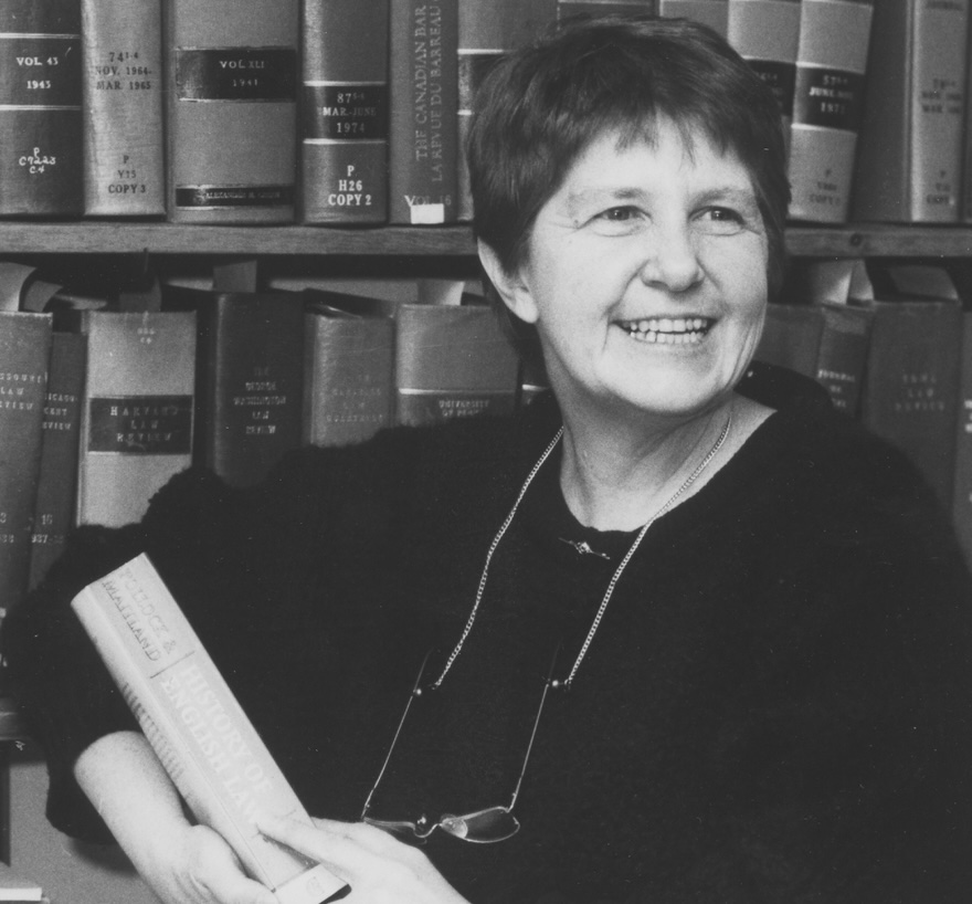 Image of Barbara Aronstein Black sitting in front of book case and looking away from the lens.